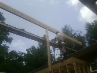 Carpenter setting a ridge beam over a new addition frame — Ice Dam Removal by Roofing Brothers in Mishicot