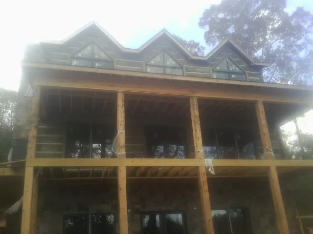 Dormers and porch framing on a large log home under construction — Roof Coating work by our crew in Mishicot