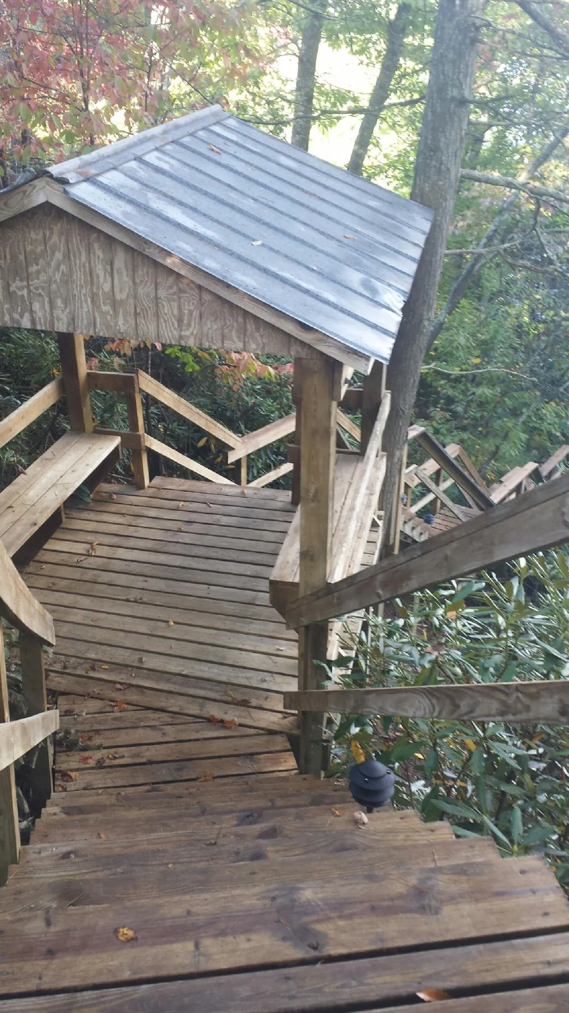 Metal roofed shelter over wooden steps on a wooded walkway — Skylight Repair & Installation work by our crew in Mishicot