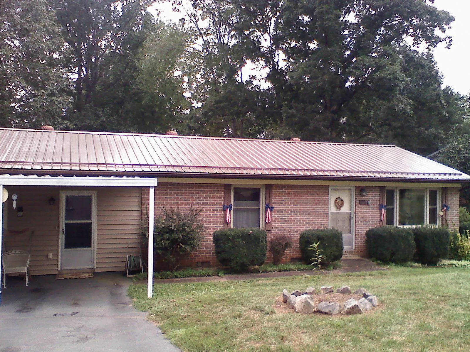 Bronze metal roof and carport on a brick ranch home — Roof Repair work by our crew in Mishicot
