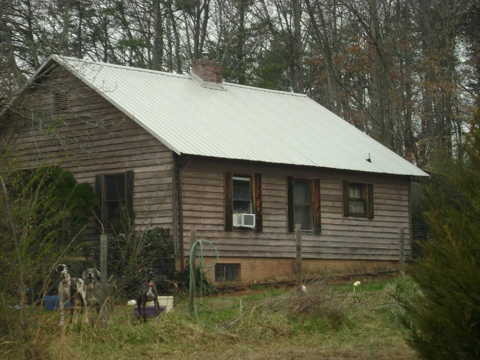 White metal roof on an old wood sided farmhouse, from a Metal Roof Installation job in Mishicot